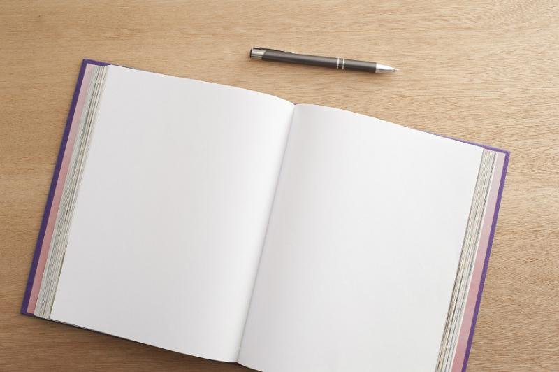 A blank notebook and pen — the blank page moment before you start writing your life story